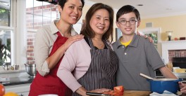 daughter and grandson gather around grandmother in her kitchen