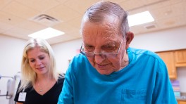 Physical therapy assistant Bridgette Jackson keeps a hand and a close eye on Jim Schoenrock during a walking exercise. 