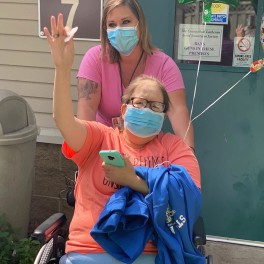 Krisann Hoskins gives a wave as she moves back to her room at Good Samaritan – Bethany. Staff member Sabrina Meide pushes her wheelchair.